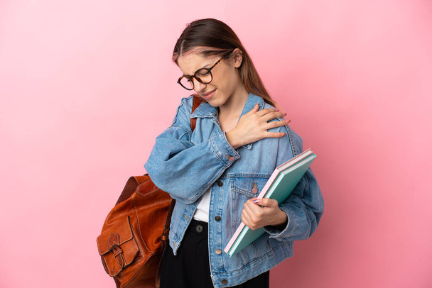 Νεαρή καυκάσια φοιτήτρια απομονωμένη σε ροζ φόντο που υποφέρει από πόνο στον ώμο επειδή κατέβαλε προσπάθεια - Φωτογραφία, εικόνα