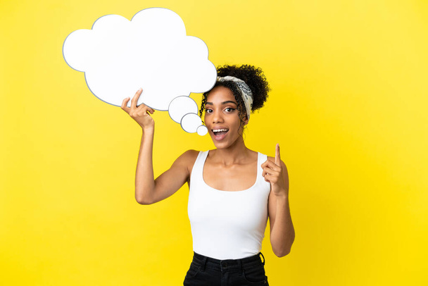 Young african american woman isolated on yellow background holding a thinking speech bubble - Foto, imagen