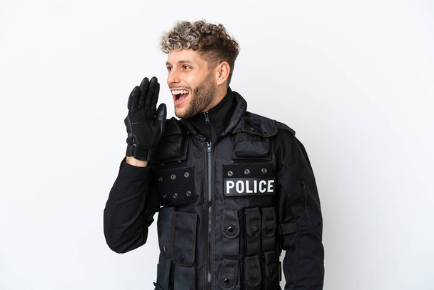 SWAT caucasian man isolated on white background shouting with mouth wide open to the lateral - Foto, Imagen
