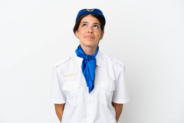 Flugzeug Stewardess kaukasische Frau isoliert auf weißem Hintergrund und Blick nach oben - Foto, Bild