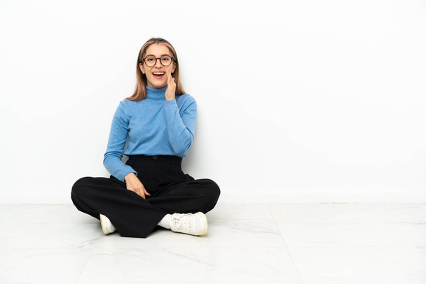 Jovem caucasiana sentada no chão gritando com a boca aberta - Foto, Imagem