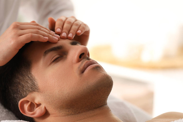 Man receiving facial massage in beauty salon, closeup - Foto, afbeelding