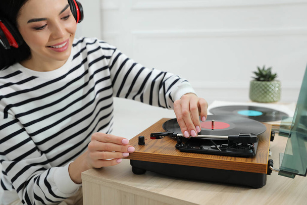 Woman listening to music with turntable at home - Фото, изображение