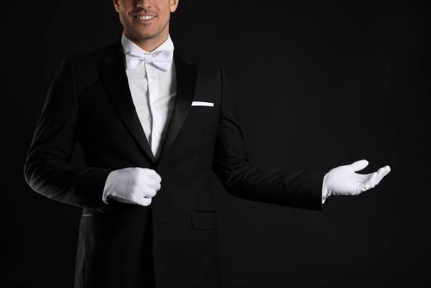 Butler in elegant uniform on black background, closeup - Fotografie, Obrázek