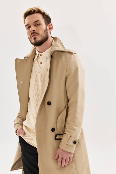 handsome man beige coat fashion studio cropped view - Foto, afbeelding