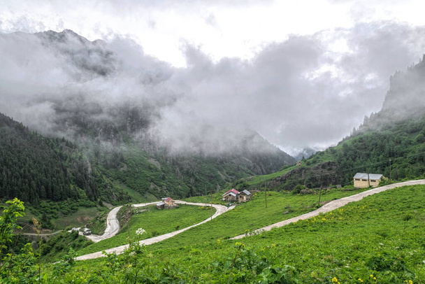Camino de montaña y nubes de tormenta sobre prados alpinos - Foto, Imagen