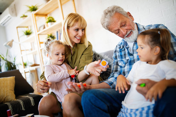 Mature grandparents playing with grandchildren and having fun with family - Valokuva, kuva