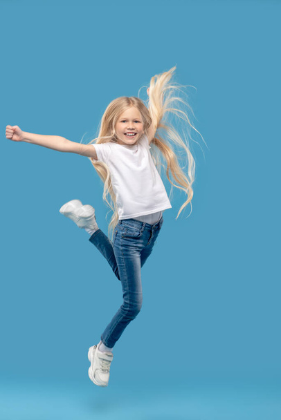 Cheerful little girl jumping in photo studio - Photo, Image