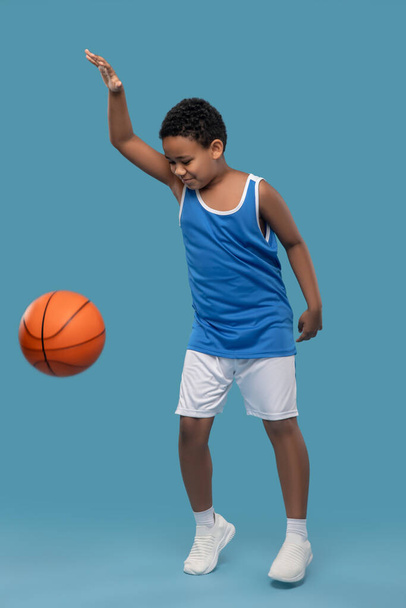 Dark skinned boy in sportswear playing ball - Foto, afbeelding