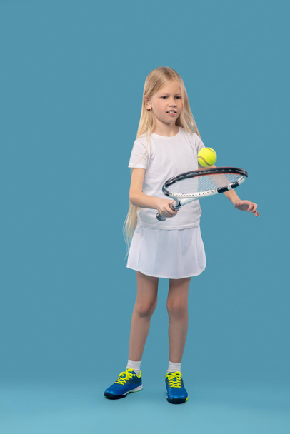 Girl exercising with tennis racket and ball - Φωτογραφία, εικόνα