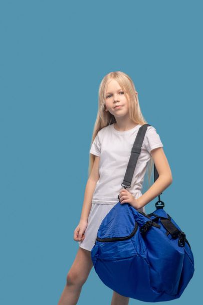 Girl standing in large sports bag on shoulder - Fotoğraf, Görsel
