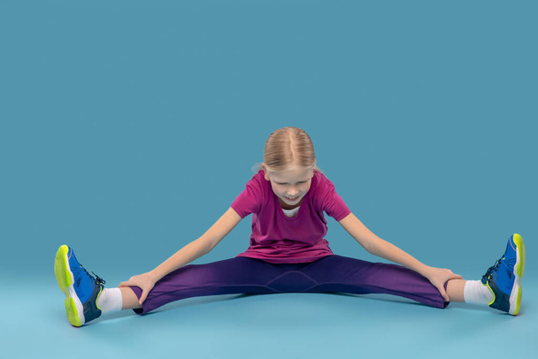 Dziewczyna na podłodze robi ćwiczenia rozciągające - Zdjęcie, obraz