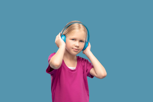Jolie fille blonde dans les écouteurs bleus - Photo, image
