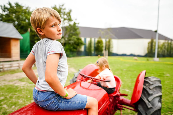 kislány és lány játszik piros játék autó - Fotó, kép