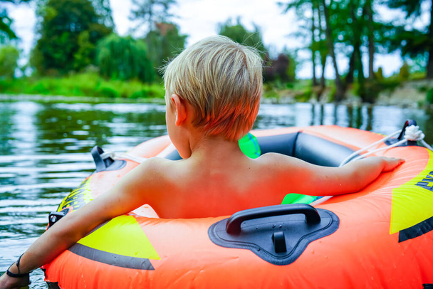 portrait of a boy in blue inflatable buoy in river - Photo, Image