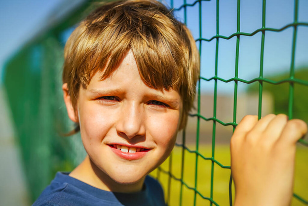 Dışarıda poz veren 9 yaşındaki sarışın bir çocuğun portresi. - Fotoğraf, Görsel