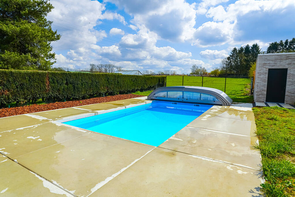 swimming pool with blue clean water and green grass - Foto, afbeelding