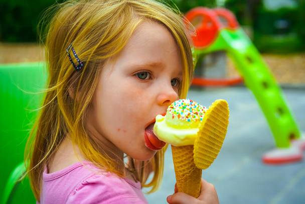 retrato de una linda niña comiendo helado en el parque - Foto, Imagen