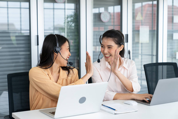 Telemarketer operators, Technical support use headset to call answer client questions and giving high five in a contact call center. Business telemarketing, Customer service, Communication telephone - Photo, Image