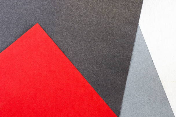 A closeup of gray, red, black, and white papers background for a copy space - Fotografie, Obrázek