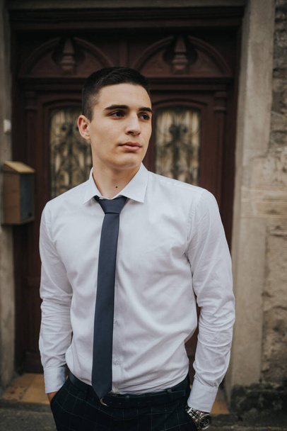 A caucasian young businessman in a tie standing outdoor. - Fotografie, Obrázek