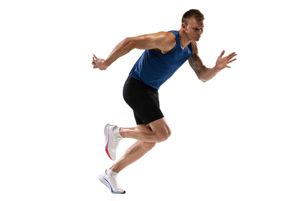 Caucasian professional male athlete, runner training isolated on white studio background. Muscular, sportive man. Concept of action, motion, youth, healthy lifestyle. Copyspace for ad. - Foto, imagen