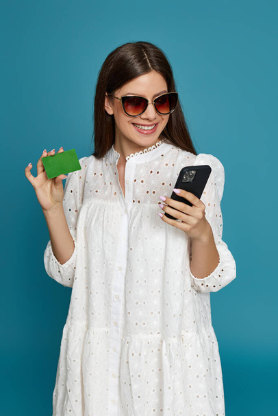 woman holding credit bank card and mobile phone - Foto, imagen