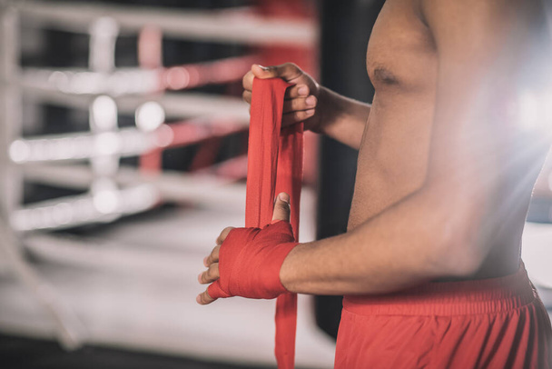 Kickboxer wpisując bandaż na ręce przed treningiem - Zdjęcie, obraz