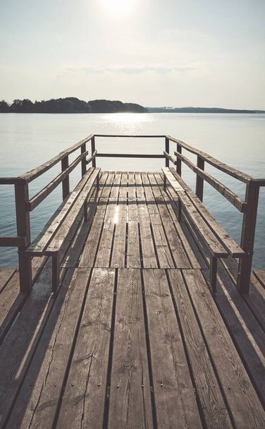 Staré dřevěné jezero molo proti slunci, barevné tónování aplikováno, Czaplinek, Polsko. - Fotografie, Obrázek