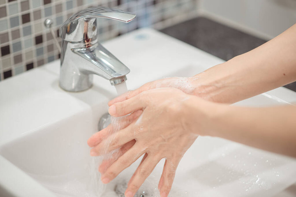 Femme utilisant du savon mousse pour se laver les mains. Concept d'hygiène détail des mains. - Photo, image