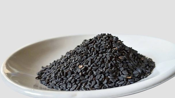 semillas de sésamo negro en un tazón aislado en blanco - Foto, Imagen