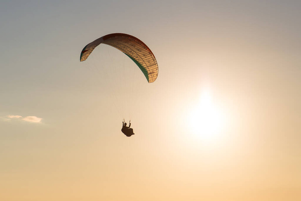 Paraglider  flying over the mountains in Austria during sunset - Fotó, kép