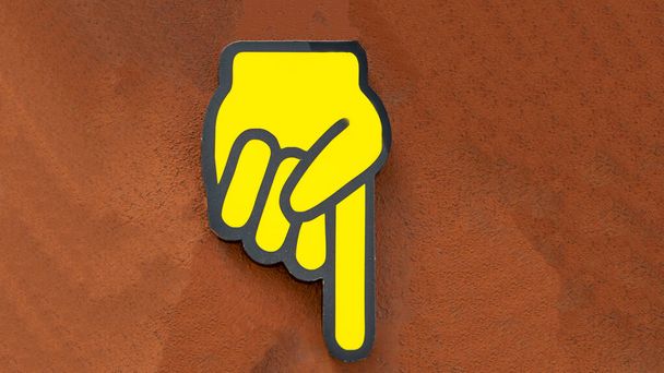 жовтий знак індексу пальця на бетонній стіні показує напрямок
 - Фото, зображення