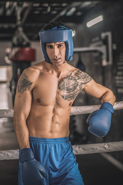 A kickboxer in a blue hemlet and in blue shorts - Photo, Image
