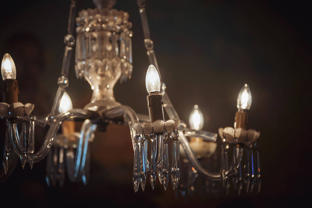 A closeup shot of a chandelier with illuminated lightbulbs - Foto, immagini