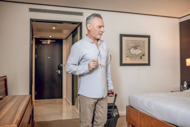 Homme confiant aux cheveux gris dans une chambre d'hôtel - Photo, image