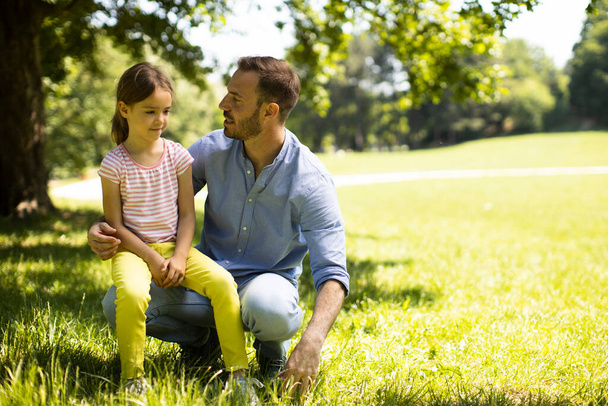 Otec s roztomilou dceruškou baví na trávě v parku - Fotografie, Obrázek