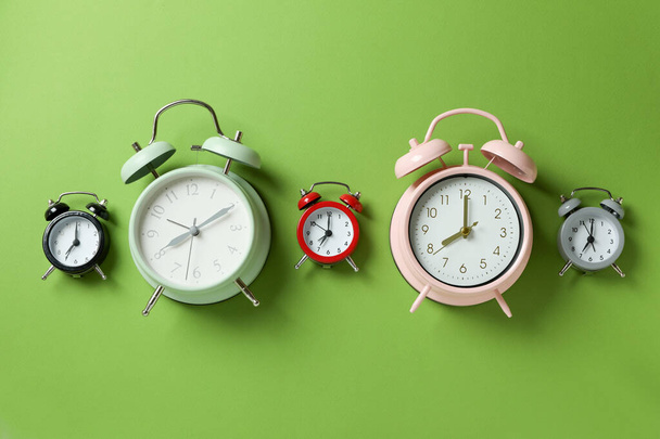 Verschillende multicolor alarm klokken op groene achtergrond - Foto, afbeelding