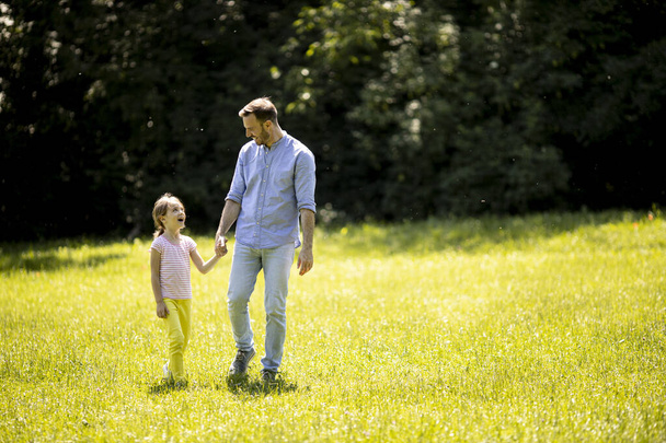 Padre con la figlioletta carina divertirsi sull'erba al parco - Foto, immagini