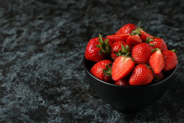Bowl of fresh strawberry on black smokey background - Photo, image