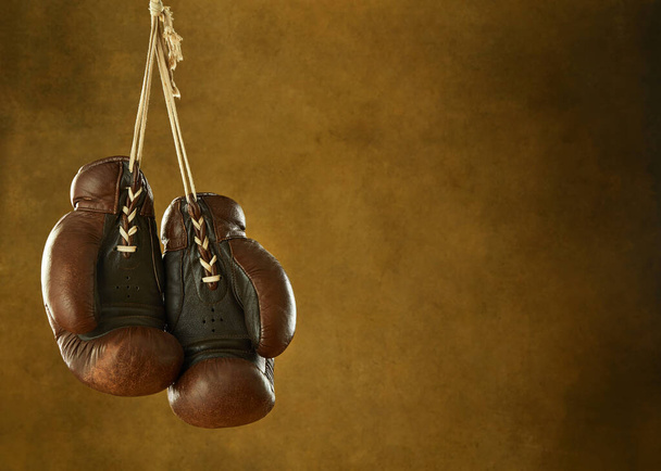 Старі боксерські рукавички, що висять на стіні
 - Фото, зображення
