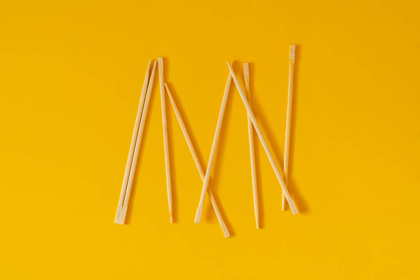 a bunch of simple wooden chopsticks flat lay isolated on the table - Photo, image