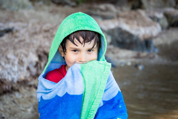 Boy wrapped in towel after swimming in the sea. Summer beach vacation concept. Holidays in France. - Foto, Imagem