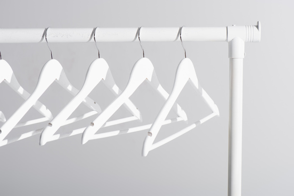 белые вешалки на вешалке для одежды, изолированные на сером - Фото, изображение