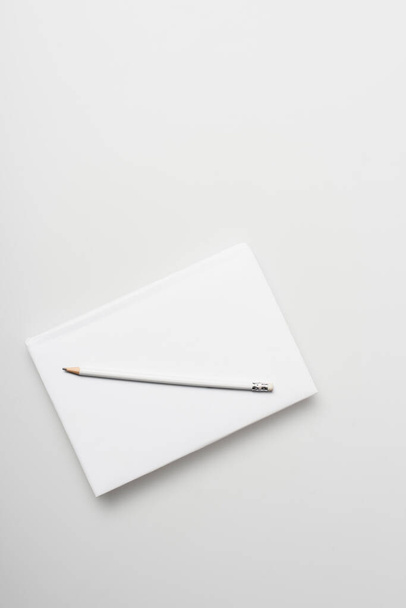 top view of notepad in hardcover with pencil isolated on white  - Foto, afbeelding