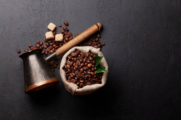 Geroosterde koffiebonen, Turkse jezve en bruine suiker. Bovenaanzicht plat lag met kopieerruimte - Foto, afbeelding