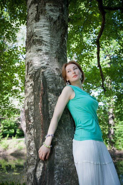  beautiful woman at a tree in summer - 写真・画像