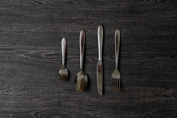 Geschirr, Besteck, Messer, Löffel und Gabel isoliert auf dem bunten Tisch - Foto, Bild