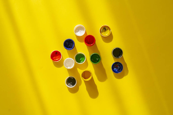 uma vista de cima do guache tintas coloridas em vasos ou latas no fundo colorido - Foto, Imagem