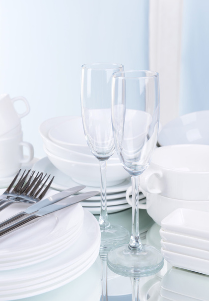 Set of white dishes on table on light background - Foto, imagen